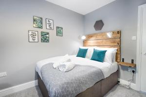 een slaapkamer met een groot bed met blauwe kussens bij Book Now - TV in Every Bedroom! in Swansea