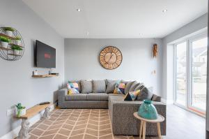 a living room with a couch and a tv at Book Now - TV in Every Bedroom! in Swansea