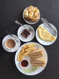 a table topped with plates of food with hot dogs and bread at Yaksha Holiday Home in Siliguri