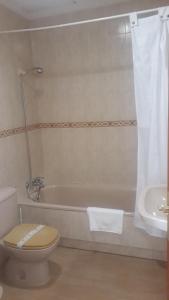 łazienka z toaletą, wanną i umywalką w obiekcie Hostal VILLA CARBULA w mieście Almodóvar del Río