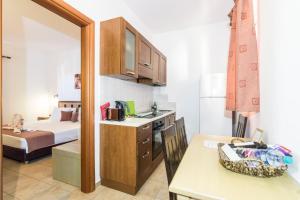 a room with a kitchen and a bedroom with a bed at Lindos Blue Sky in Líndos