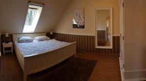a bedroom with a bed and a window and a mirror at Ferienwohnung Wasserlilie in Kolonie