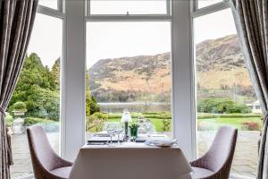 
a room with a table, chairs, and a window at The Inn On The Lake in Glenridding
