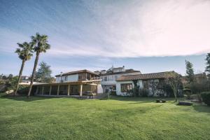 a large house with a palm tree in a yard at La Casona de Amandi in Villaviciosa