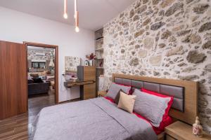 a bedroom with a stone wall and a bed at Zaros Villa Fountarinis in Zaros