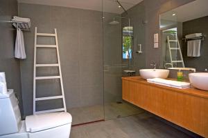een badkamer met een wastafel, een toilet en een spiegel bij Eriyadu Island Resort in Reethi Rah