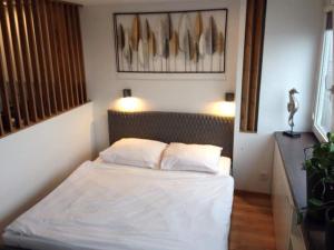 1 dormitorio con 1 cama con sábanas y almohadas blancas en Alma Apartments Smolna en Varsovia