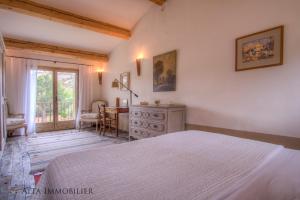 um quarto com uma cama, uma mesa e uma janela em Villa Serenita Pallombaggia em Porto-Vecchio