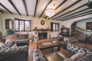 a living room with leather furniture and a fireplace at La Casona de Amandi in Villaviciosa