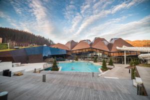 um grande edifício com uma piscina em frente em Farm stay Žurej em Šentjur