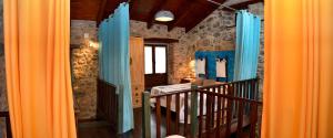 um corredor com cortinas azuis e laranja num quarto em Casas Rurales Entre Babia y La Luna em Villafeliz