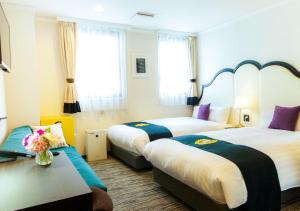 a hotel room with two beds and a table at Grand Park Hotel Panex Tokyo in Tokyo