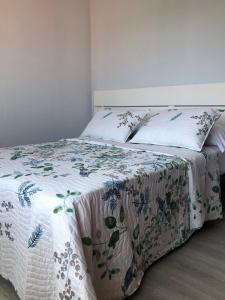 una camera da letto con un letto con copriletto floreale di Lemos Nube a Monforte de Lemos