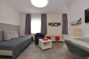 niewielka sypialnia z łóżkiem, biurkiem i biurkiem w obiekcie Hotel Wolke w mieście Meiningen