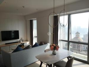 a living room with a table and a large window at Ascott Raffles City Chongqing in Chongqing