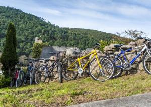 a group of bikes parked next to a stone wall at Casa Do Centeal in Arrueiro