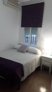 - une chambre avec un lit, un bureau et une fenêtre dans l'établissement Hostal VILLA CARBULA, à Almodóvar del Río