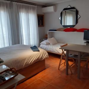 - une chambre avec un lit, un bureau et un miroir dans l'établissement Pequeño y Coqueto Piso en Riaza, à Riaza