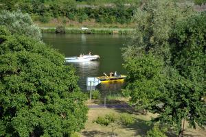 two boats on a river with people in them at Pension Mosella , Wohnung mit Balkon und Moselblick in Sankt Aldegund