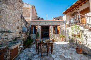 a stone house with a table in a courtyard at Constantias stone houses in Lofou