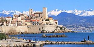 a town on the shore of a body of water with mountains at My rima in Antibes