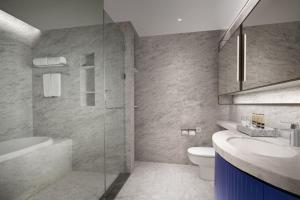 a bathroom with a sink and a toilet and a shower at Ascott Raffles City Chongqing in Chongqing