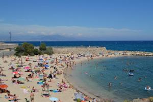a beach with a lot of people in the water at My rima in Antibes