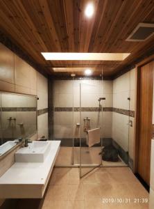 y baño con lavabo y ducha. en Giyoche Motel, en Wanli
