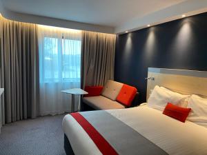 a hotel room with a bed and a chair at Holiday Inn Express Ramsgate – Minster by IHG in Minster