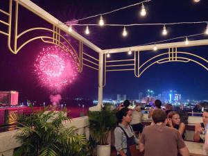 a crowd of people sitting on a rooftop watching a fireworks show at Point Boutique Hotel in Phnom Penh
