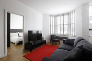 - un salon avec un canapé et un tapis rouge dans l'établissement Clarence Square, à Brighton et Hove