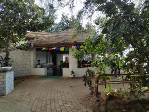 une maison avec toit de chaume et patio dans l'établissement Red Earth - Gokarna, à Ankola