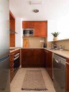 a kitchen with wooden cabinets and a sink at Homing Barcelona 101 in Barcelona