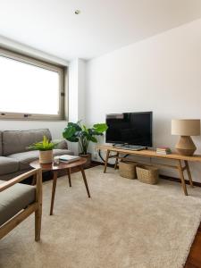 uma sala de estar com um sofá e uma televisão em Homing Barcelona 101 em Barcelona