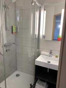 La salle de bains est pourvue d'une douche et d'un lavabo. dans l'établissement initial by balladins Tours Sud, à Chambray-lès-Tours