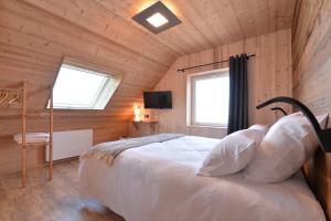 um quarto com uma cama num chalé de madeira em Le Clos Ô Daims em Widensolen