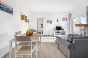 a white living room with a table and a couch at APARTAMENTO COR DO MAR - Sunny, Clean and spacious apartment with sea view, in Alvor - very close walking distance to the beach and Alvor Village in Alvor