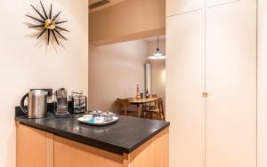 a kitchen with a counter and a clock on the wall at Comfy 1BR apartment Montaigne Champs-Elysées in Paris
