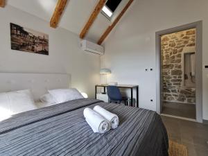 a bedroom with a large bed with towels on it at FJAKA Boutique Apartments in Split