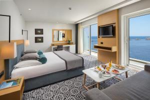 a hotel room with a large bed and a television at Royal Neptun Hotel in Dubrovnik