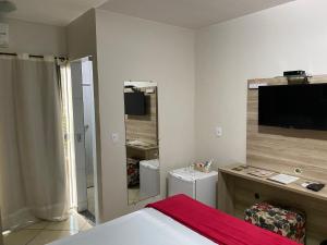 a hotel room with a bed and a television at Hotel Golden JK in Muriaé