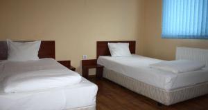 1 dormitorio con 2 camas con sábanas blancas y ventana en ХОТЕЛ РАДНЕВО en Radnevo
