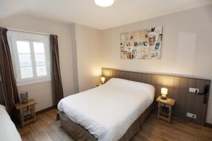 a bedroom with a white bed and a window at Contact Hôtel - Hôtel Le Lion d'Or Lamballe in Lamballe