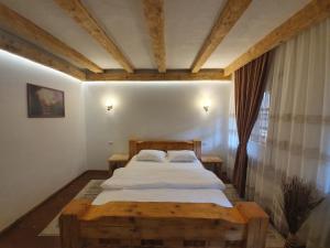 a bedroom with a large bed with a wooden frame at Păstrăvăria Alex in Mara