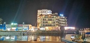 仙本那Sipadan Inn 3的水体旁边的一座大建筑