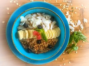 a blue bowl of food with fruit and vegetables on a table at Mantra Gili in Gili Trawangan