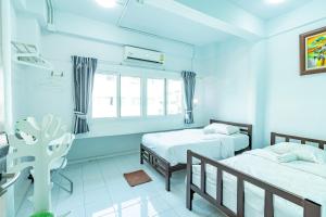 a blue room with two beds and a window at Sleep Dee Hostel in Bangkok