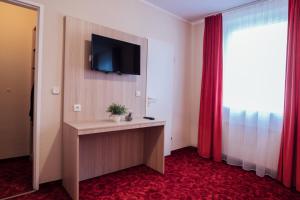 um quarto de hotel com televisão e tapete vermelho em Hotel CULT Hamburg em Hamburgo