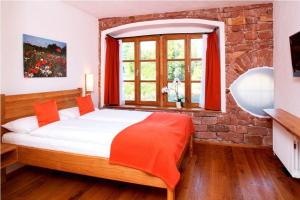 a bedroom with a bed and a brick wall at Hotel Gut Hühnerhof in Gründau