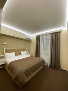 a bedroom with a large bed and a window at Hotel Obolon in Kyiv